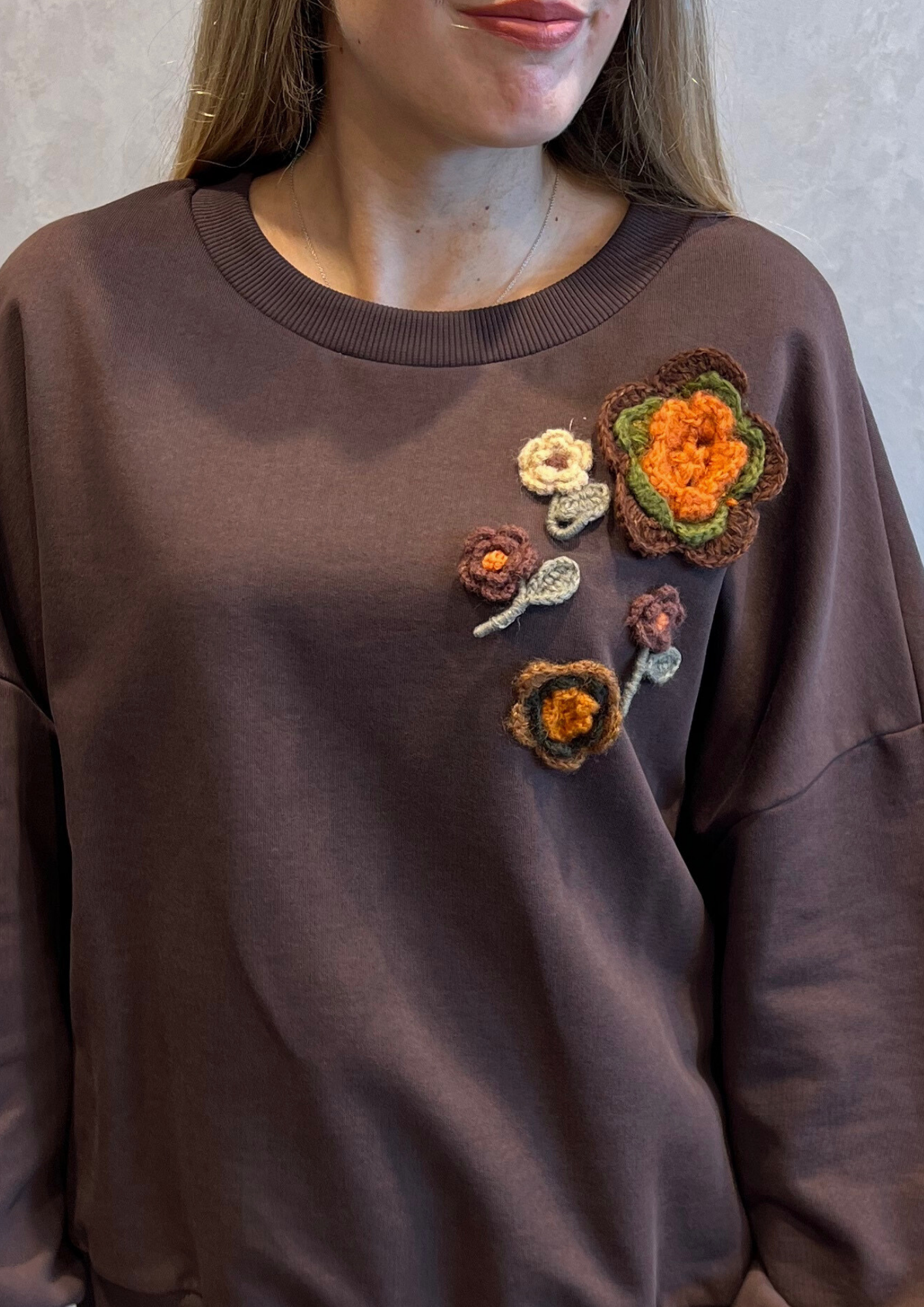 Felpa over garzata con fiori all'uncinetto
